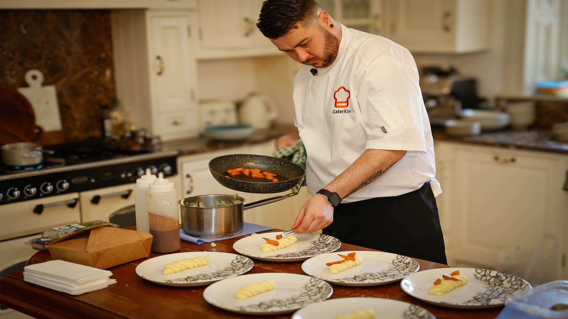 Chef carefully plating dishes in a home kitchen