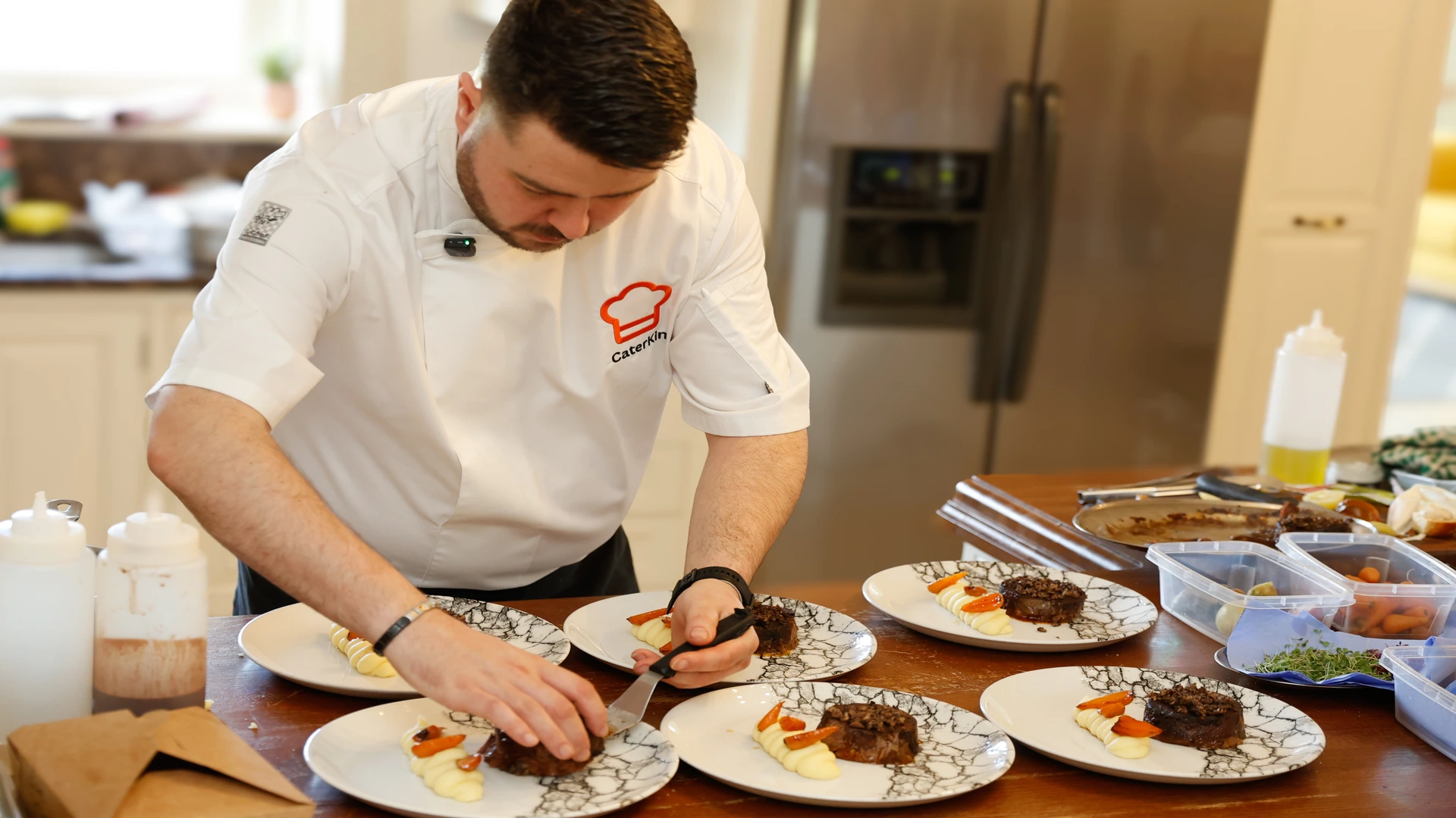 Chef in CaterKin whites focused on plating a gourmet dish