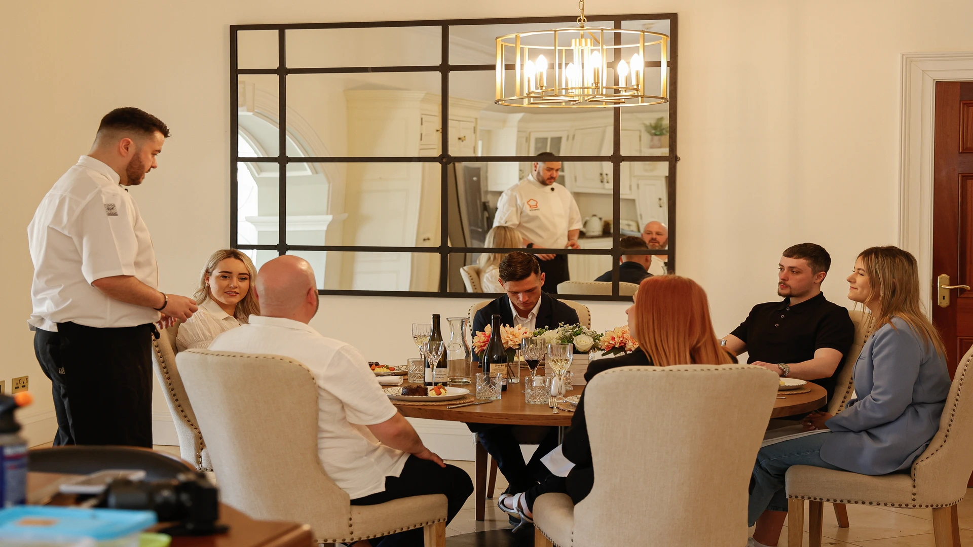 Chef interacting with guests around the dinner table