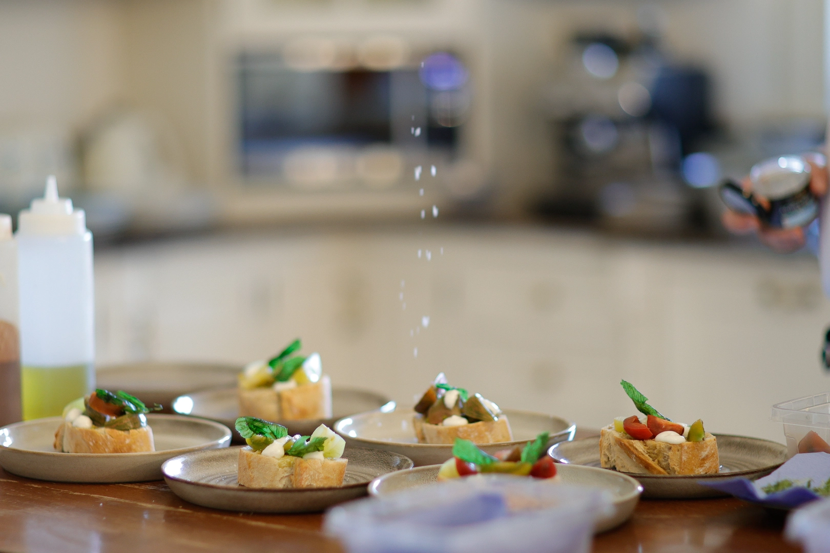 Fresh bruschetta canapes being plated with seasoning for a catering event